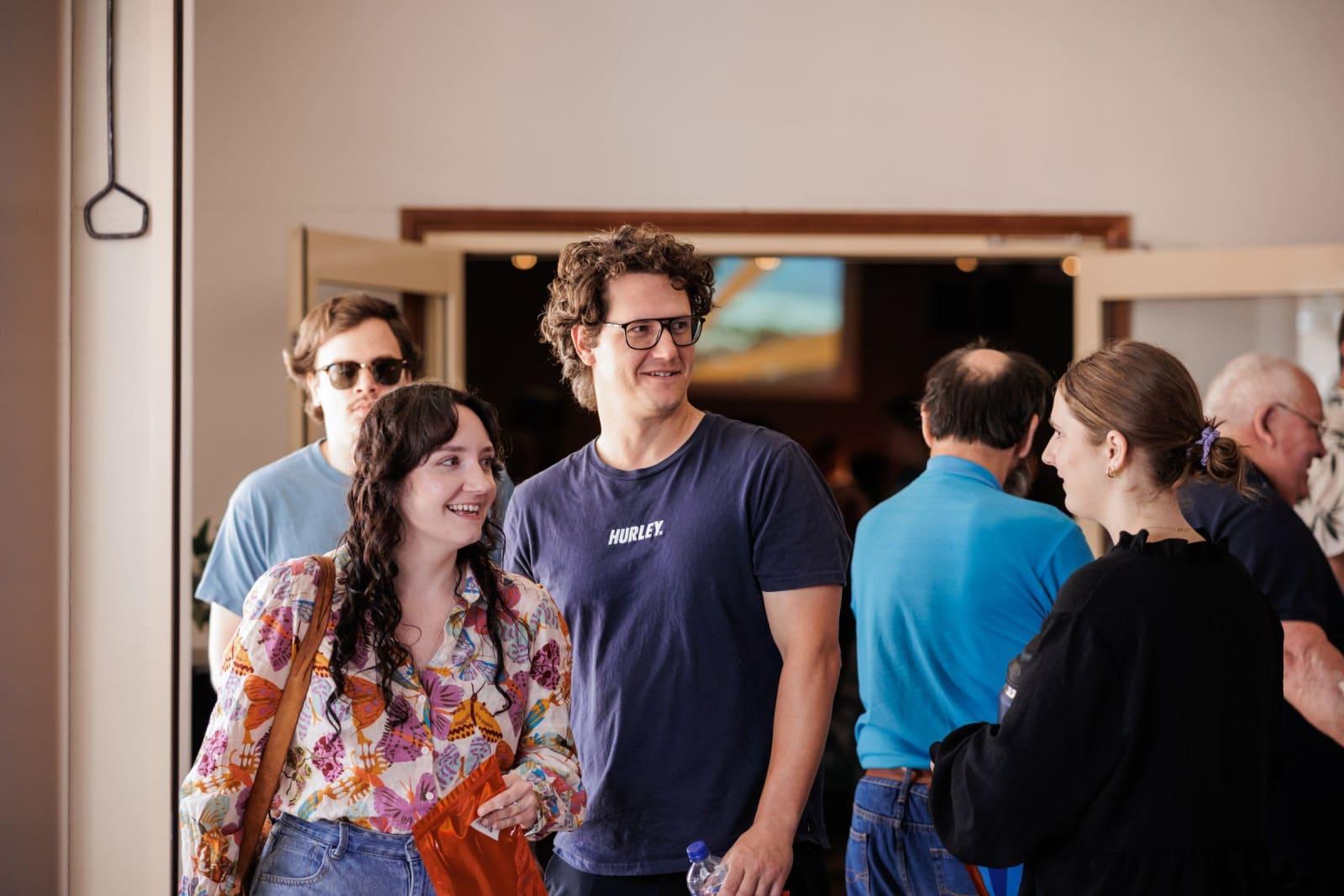 Friends walking into the foyer mid-conversation, smiling