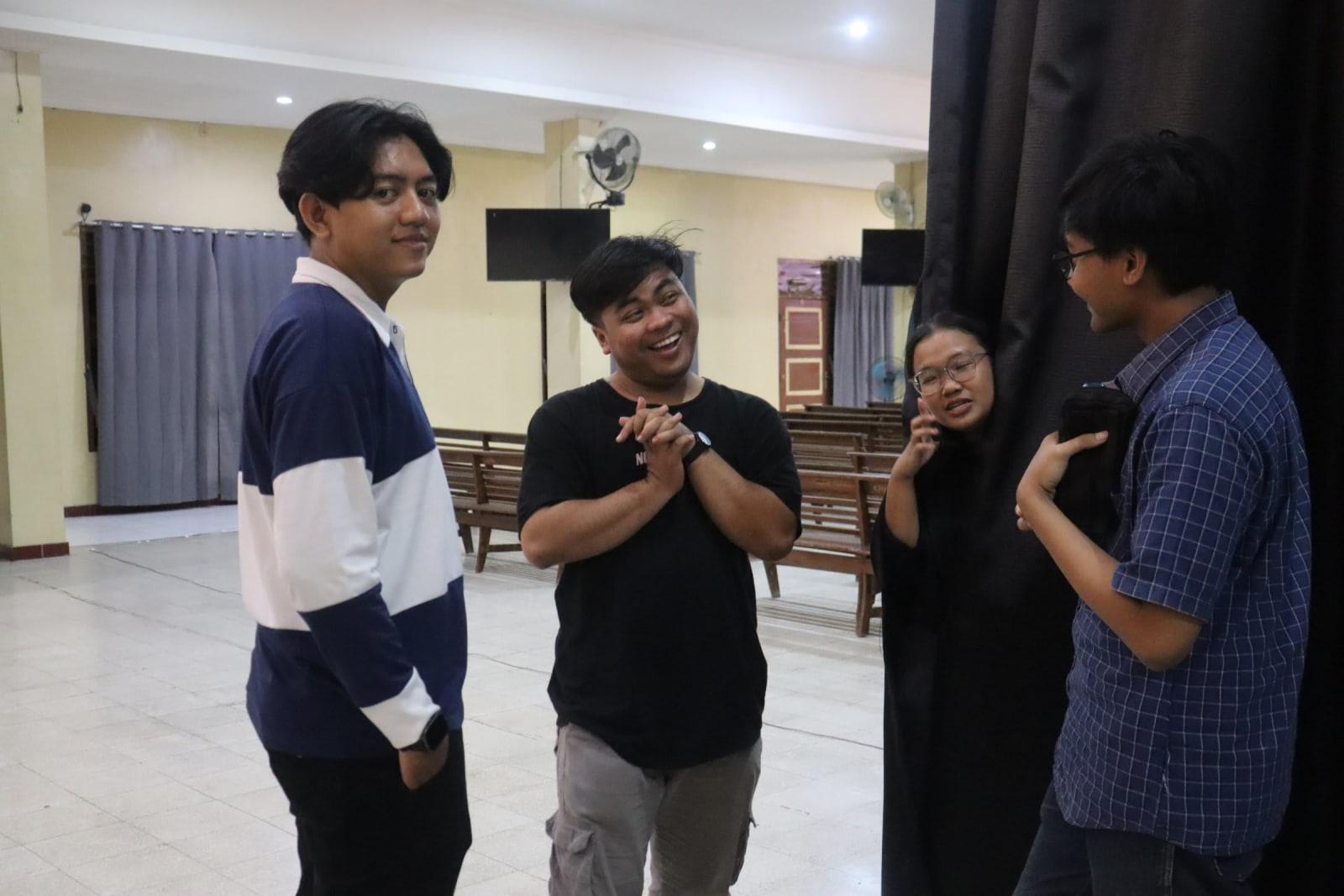 Four young friends cracking up together in the church hall at Solo