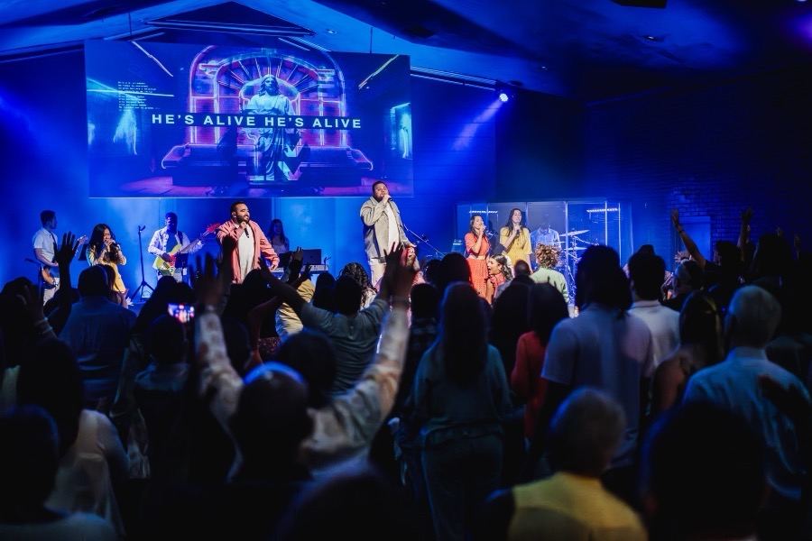 A diverse congregation worshipping with hands raised at Futures Kennesaw